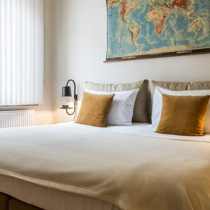 romatisch bed met wereldkaart, sierkussens, nachtkastjes in de derde verdieping flat van aplace antwerp