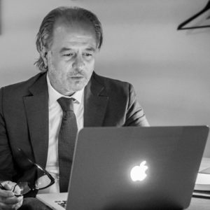 een zwart wit foto van een oudere man die op laptop aan het werken is aan het bureau in de square view suite van aplace antwerp